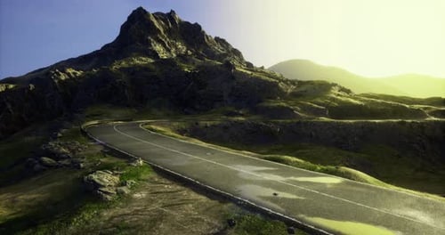 Scenic Winding Road Leading to a Mountain During Golden Hour