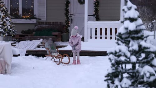 Little Girl Playing with Sled in Snowy Winter