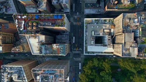 Through the streets of New York City, people and vehicles travel. Aerial