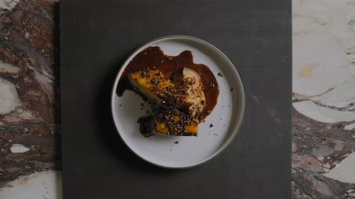 Overhead shot of a chef plating a gourmet sweet potato dish in a restaurant