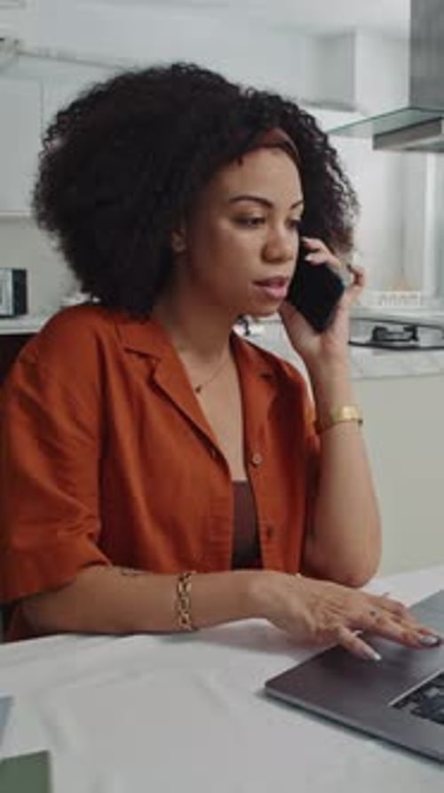 Woman Telecommuting at Home with Laptop and Phone