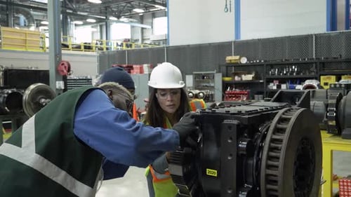 Ingénieurs de transport en commun inspectant des machines dans une installation de maintenance pour adultes