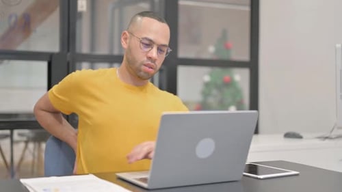 Man Using Laptop and Experiencing Back Pain