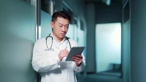 Asian male doctor advise patient remotely using digital tablet. Communicates online talks on video