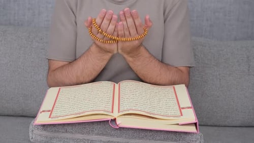 Man Sitting with Prayer Beads and Religious Book