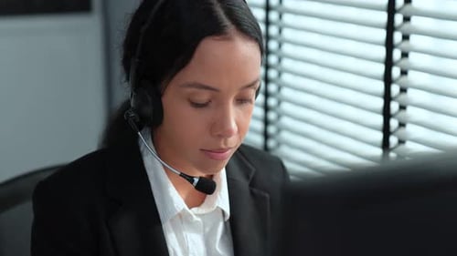 Kompetente Bedienerin, die am Computer arbeitet und mit Kunden spricht