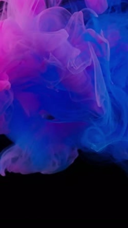 Pink and Blue Ink Swirling in Dark Space