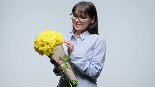 Young Woman Smelling Bright Yellow Daffodil Bouquet