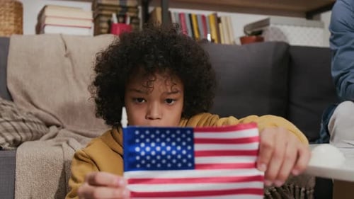 Child Holding American Flag Indoors