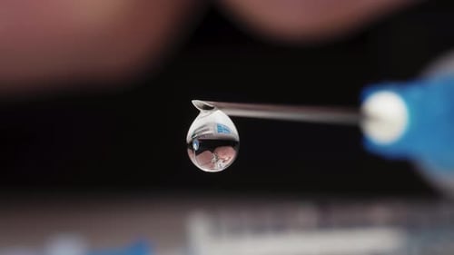 Syringe Needle with Clear Liquid Droplet Close-Up