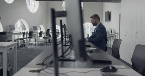Businessman Working on Computer in Empty Corporate Office
