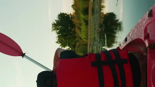 Man Paddling Kayak on Quiet River