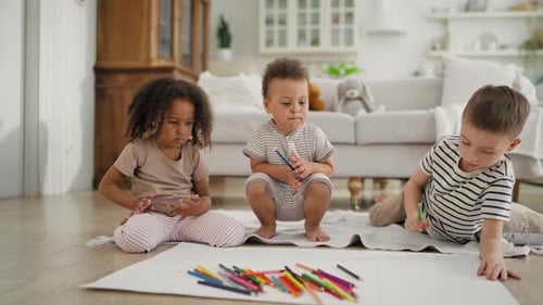 Three Children Drawing on Paper Together Indoors