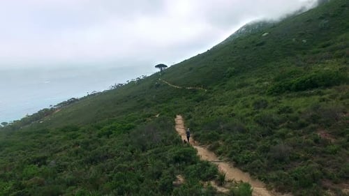 Drone, person is running and path in mountains, nature and landscape for fitness outdoor