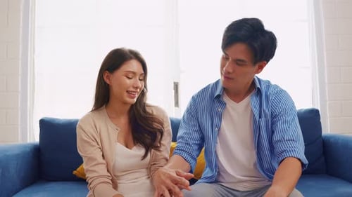 Loving Couple Holding Hands on a Blue Couch