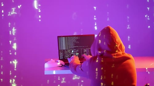 Un mystérieux hacker tape rapidement dans une pièce bleue brillante, entourée de symboles numériques en cascade.
A.