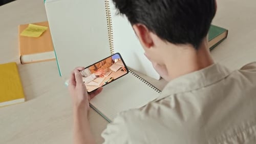 Niño que usa el teléfono furtivamente durante el horario de clase
