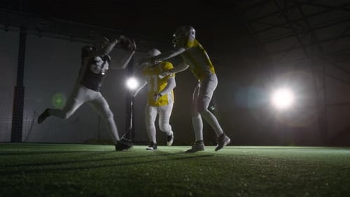 American Football Player Catching Ball and Running while Tackled by Rivals