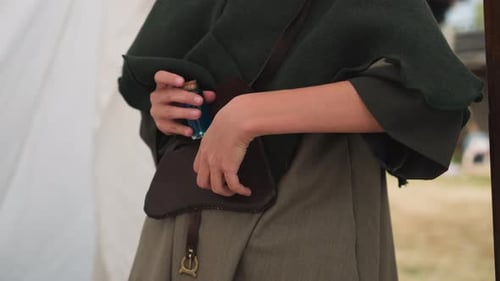 Medieval Clothing Person Places Bottle in Pouch