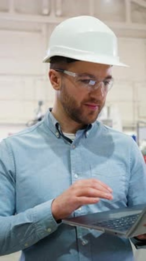 Chief Engineer With Laptop On Factory Analyzes The Production Process Vertical Video