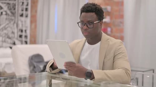Cheerful African American Man using Tablet PC