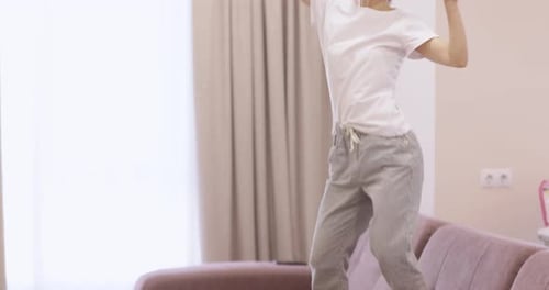 Woman Dancing Joyfully on Couch at Home