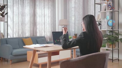 Woman Analyses Stock Market Data on Laptop