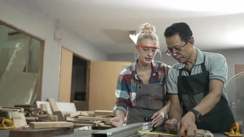 Carpenters are working together at workshop.