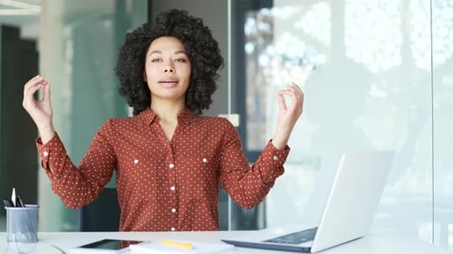 Woman Meditating at Desk in Modern Office