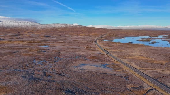 Aerial revealing shot of the A82 running through the Rannoch Moor in ...