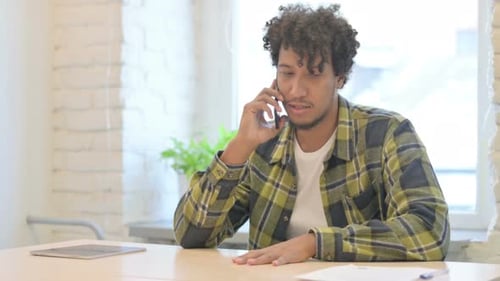 African Man Talking on Phone in Office