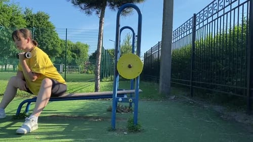 Young woman works out at the sport area outdoors