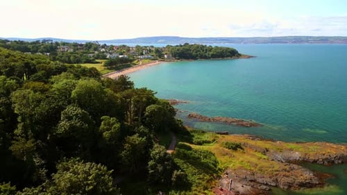 Rising aerial video of Helen's Bay beach in County Down, Northern Ireland, UK on a bright day.