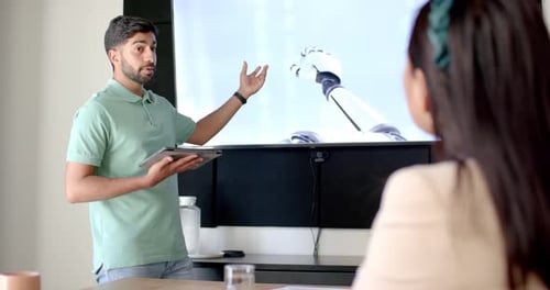 Presenting data, man holding tablet and explaining to colleague in office meeting