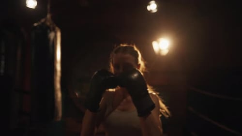 Woman Shadow Boxing in Boxing Ring at Night