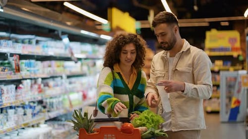 Couple Reading Grocery Receipt in Grocery Store