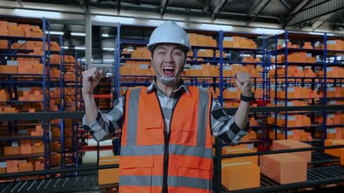Asian Male Engineer Screaming Goal Celebrating Working In The Warehouse