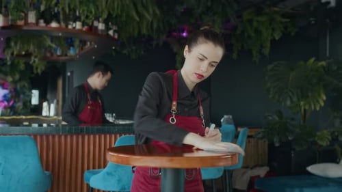 Caucasian Waitress Wiping Tables before Cafe Opening