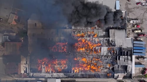 Flamme rougeoyante et fumée lors de l'incendie d'une maison d'un entrepôt d'une usine industrielle dans la banlieue de la ville