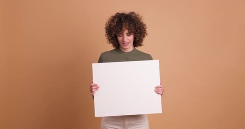 Happy Woman Holding Blank Paper in Beige Studio