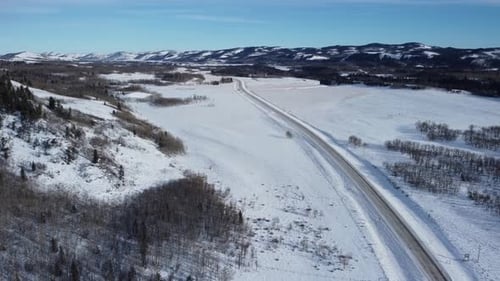 Winter highway in daytime covered with snow. Aerial view.