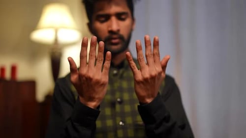 Young Man with Raised Hands Indoors