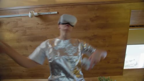 Young Adult Using VR Headset with Controllers
