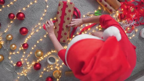 A Young Woman is Packing Christmas Presents for Her Friends and Relatives
