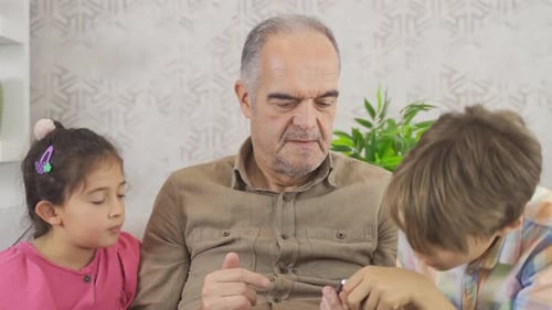 Adult and Children Using a Smartphone on Couch