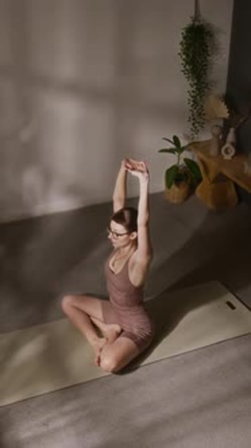 Woman Doing Yoga Stretches Indoors on a Mat