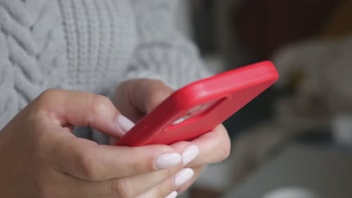 Woman's Hands Using Red Smartphone, Close Up