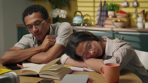 Tired African American Guy and Girl Sleeping on Kitchen Table Home After Studying Exhausted High