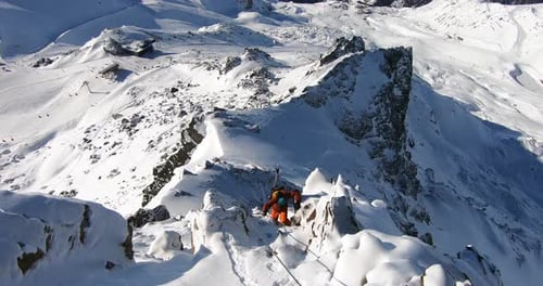 Mountain climbing in snow with a young mountaineer in the tyrolean alps Austria. Climbing up a steep