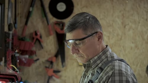 A Craftsman Works with a Wooden Block in His Workshop